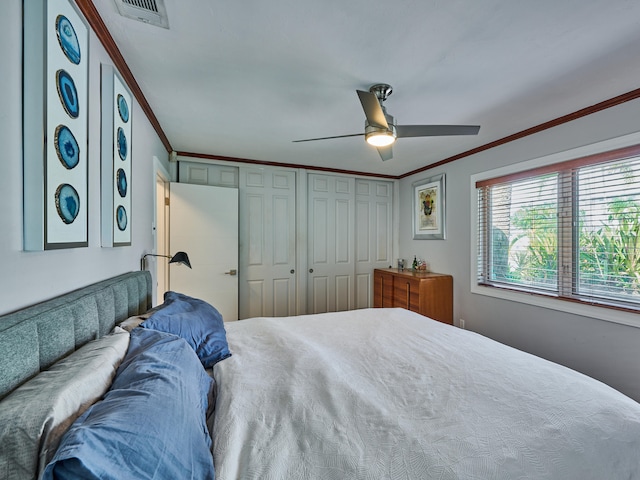 bedroom with ornamental molding, ceiling fan, and a closet