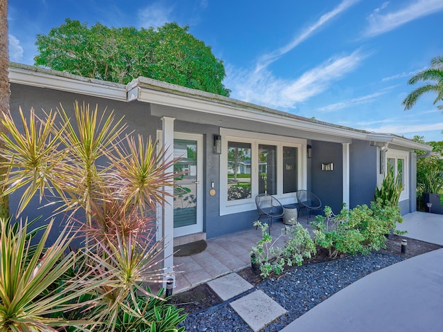 property entrance featuring stucco siding and a porch