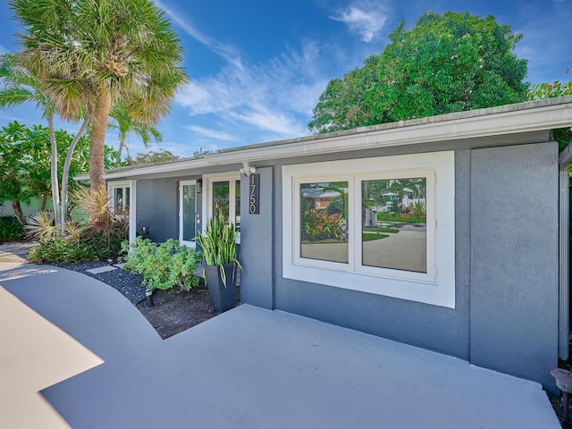 entrance to property featuring stucco siding and a patio