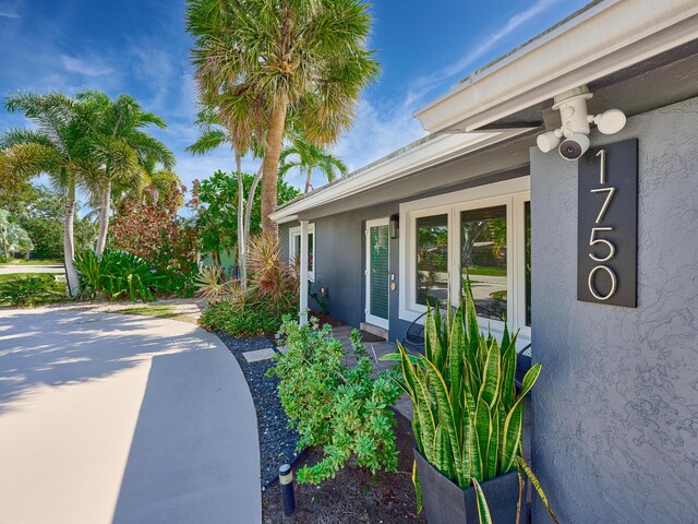 doorway to property featuring stucco siding, french doors, and a patio area