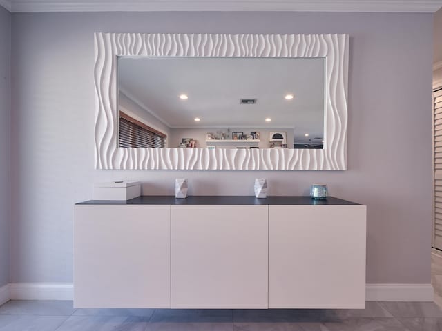 bar featuring white cabinets, light tile patterned flooring, and crown molding