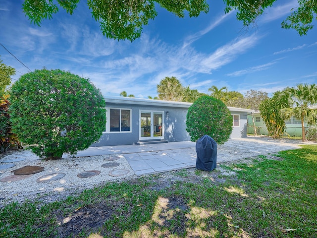 view of front of home with french doors, a patio, and stucco siding