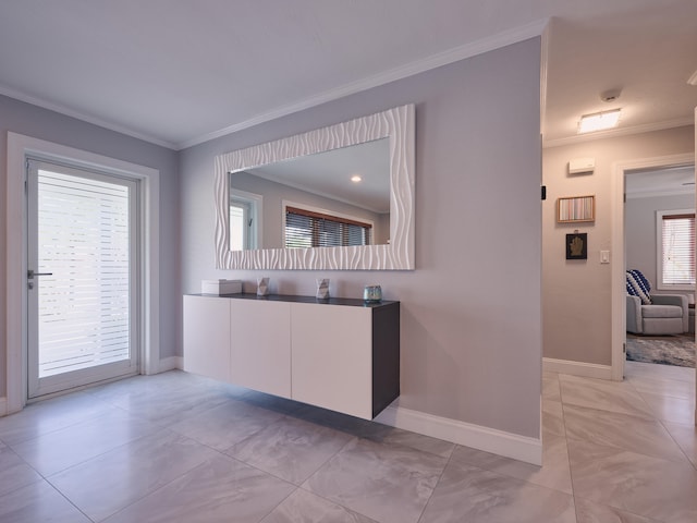 kitchen with light tile patterned flooring, ornamental molding, and white cabinets