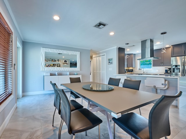 dining space featuring a wealth of natural light, sink, and crown molding