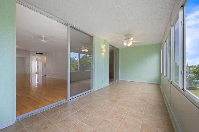 unfurnished sunroom with ceiling fan