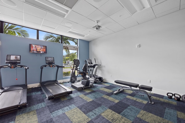 gym with a drop ceiling and carpet