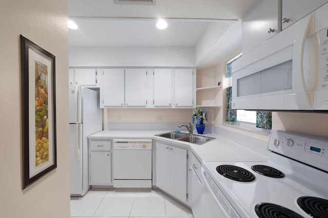 kitchen with white appliances, white cabinetry, sink, and light tile patterned floors