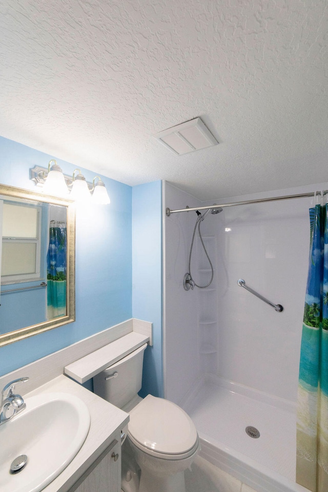 bathroom featuring walk in shower, vanity, toilet, and a textured ceiling