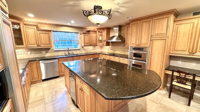 kitchen featuring sink, wall chimney exhaust hood, decorative light fixtures, a kitchen island, and stainless steel appliances