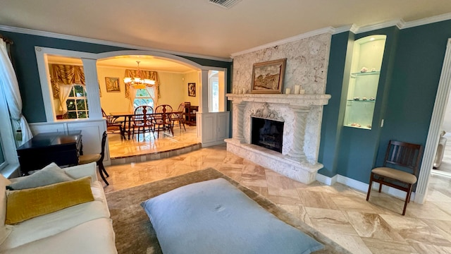 living room with a fireplace, a chandelier, ornate columns, and crown molding