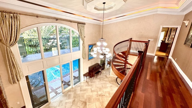 interior space featuring ornamental molding, an inviting chandelier, and a tray ceiling