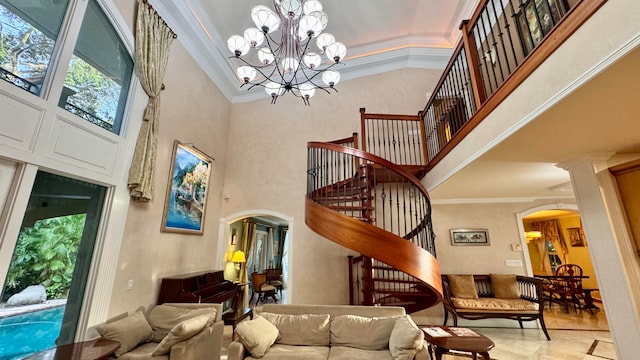 interior space featuring crown molding, a towering ceiling, and a notable chandelier