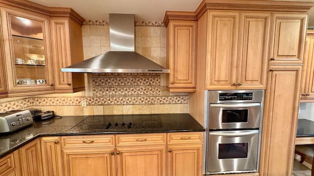 kitchen with stainless steel double oven, tasteful backsplash, wall chimney exhaust hood, and black electric cooktop