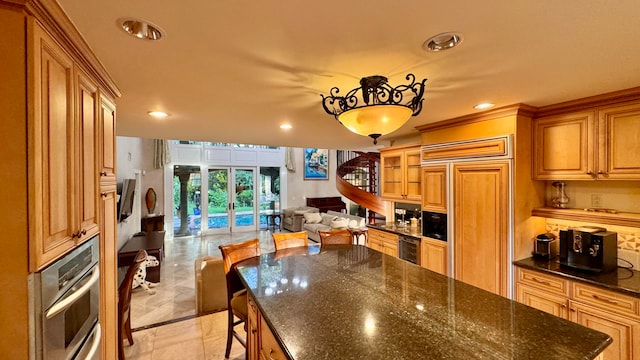 kitchen featuring pendant lighting, oven, wine cooler, paneled fridge, and a breakfast bar area