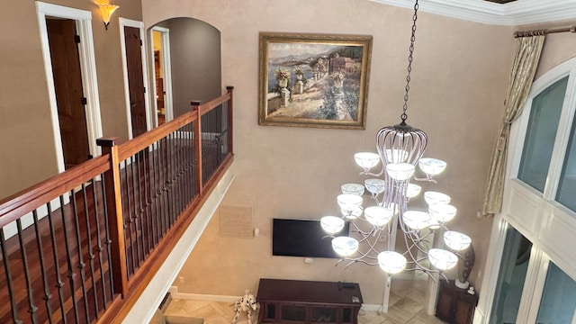 corridor featuring crown molding and a notable chandelier