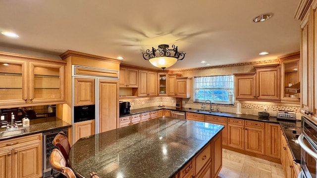 kitchen featuring dark stone counters, sink, decorative backsplash, stainless steel appliances, and beverage cooler