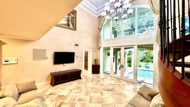 living room featuring a high ceiling, an inviting chandelier, french doors, and ornamental molding