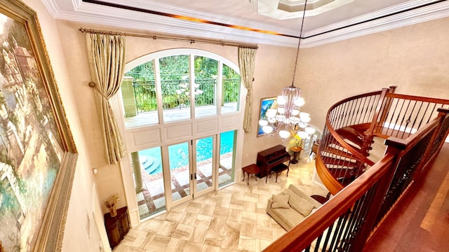 interior space featuring a raised ceiling, ornamental molding, and a chandelier