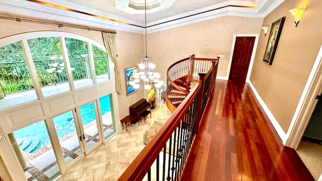 hallway with a tray ceiling, crown molding, dark hardwood / wood-style flooring, and a notable chandelier