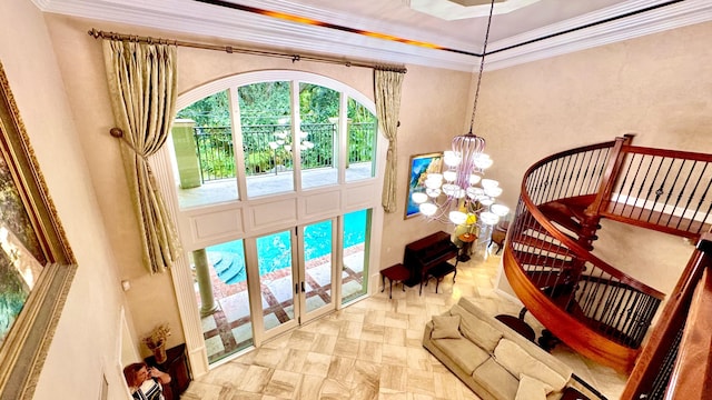 interior space featuring a raised ceiling, ornamental molding, and a notable chandelier