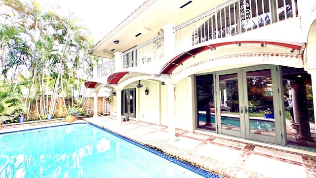 view of swimming pool featuring french doors