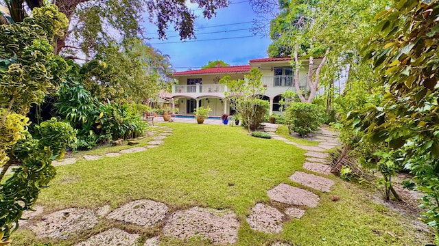 view of yard with a balcony and a swimming pool