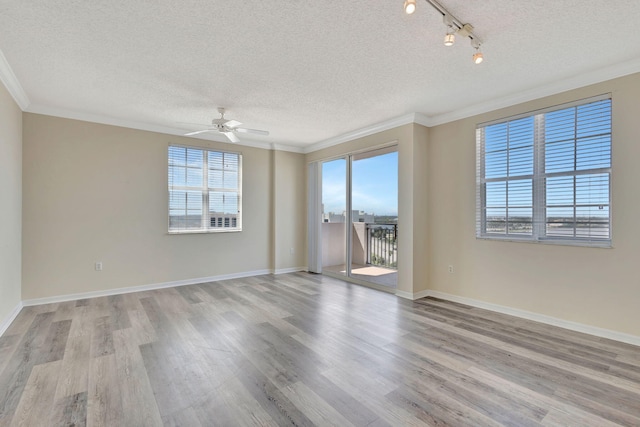 empty room with a textured ceiling, crown molding, light hardwood / wood-style floors, and ceiling fan