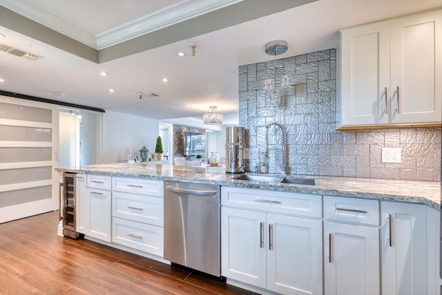 kitchen with stainless steel dishwasher, white cabinets, and wood-type flooring