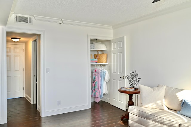 sitting room with ornamental molding, a textured ceiling, and dark hardwood / wood-style floors