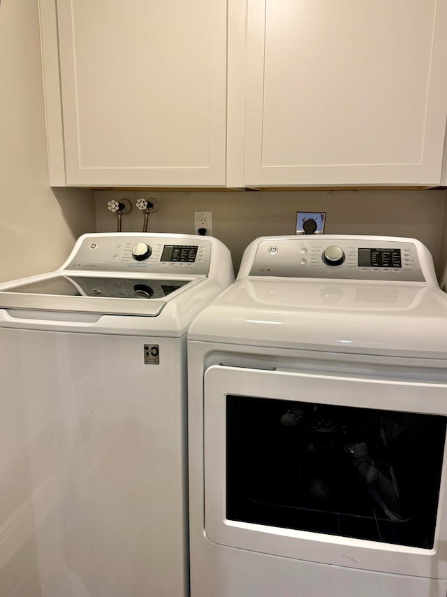 washroom featuring cabinets and washer and dryer