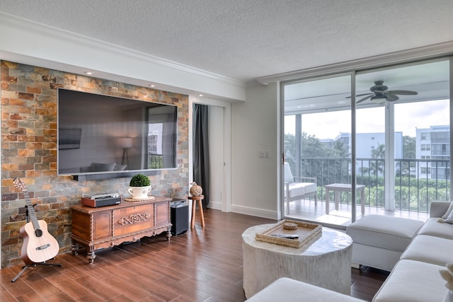 living room featuring dark wood-type flooring, ceiling fan, crown molding, and a textured ceiling