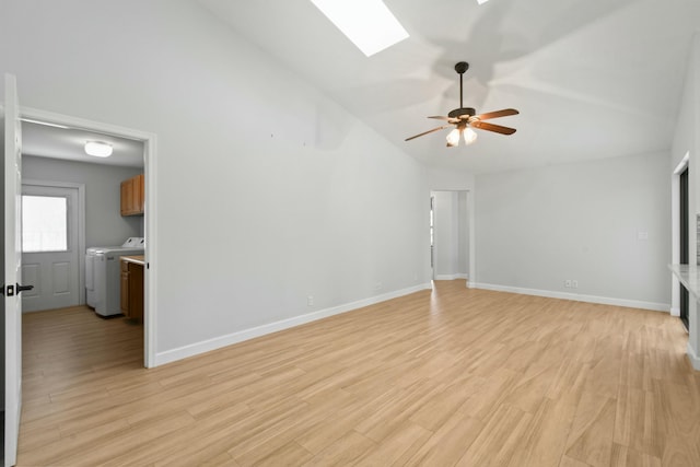 unfurnished living room with vaulted ceiling with skylight, ceiling fan, light wood-type flooring, and separate washer and dryer