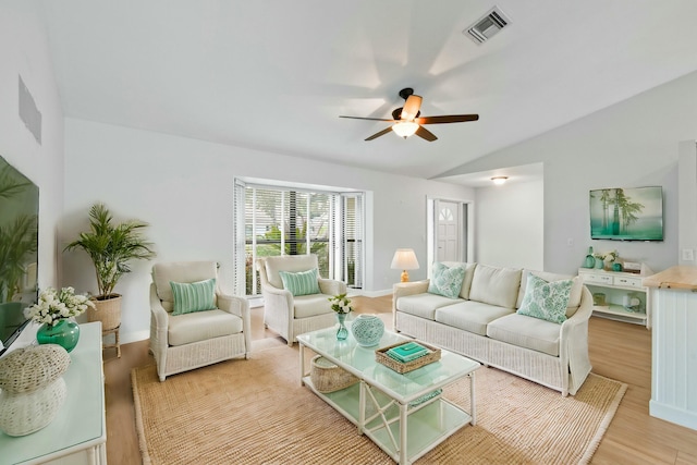 living room featuring light hardwood / wood-style floors, vaulted ceiling, and ceiling fan