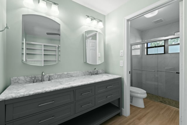 bathroom with toilet, vanity, an enclosed shower, and hardwood / wood-style flooring