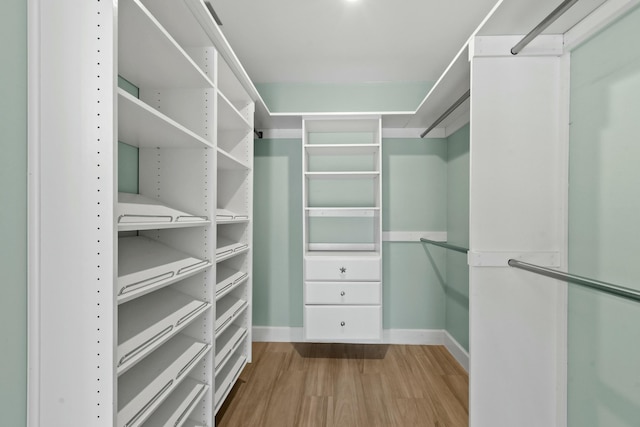 walk in closet with light hardwood / wood-style flooring