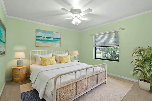 carpeted bedroom with ceiling fan and ornamental molding