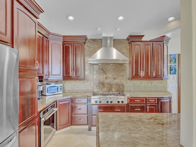 kitchen with appliances with stainless steel finishes, wall chimney exhaust hood, decorative backsplash, and light stone countertops