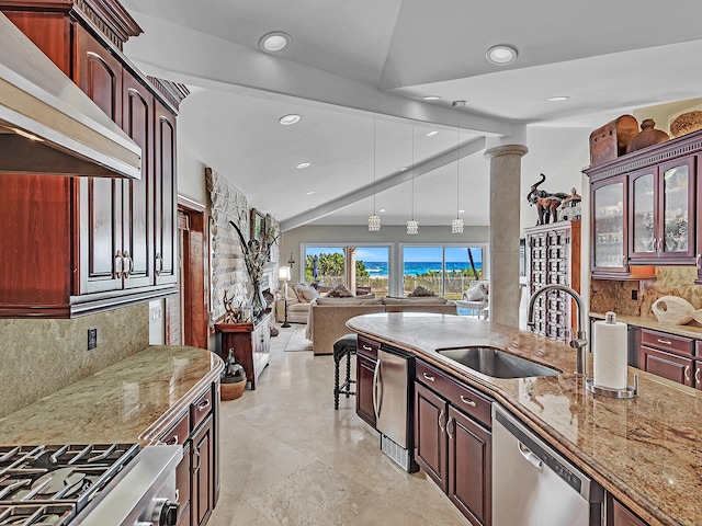 kitchen featuring decorative backsplash, sink, ornate columns, wall chimney range hood, and appliances with stainless steel finishes