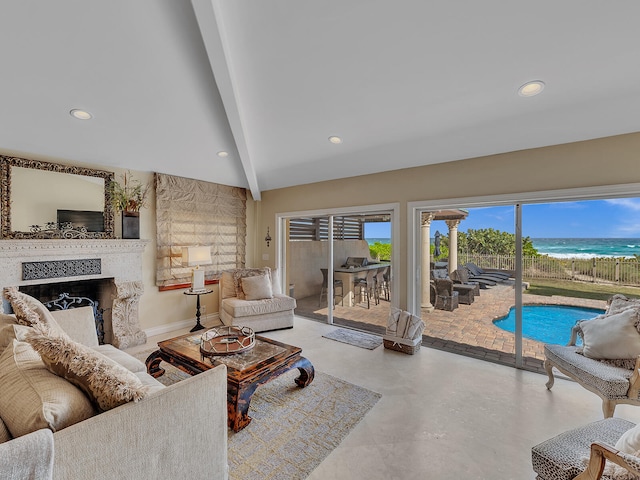 living room with a water view, beamed ceiling, and concrete floors