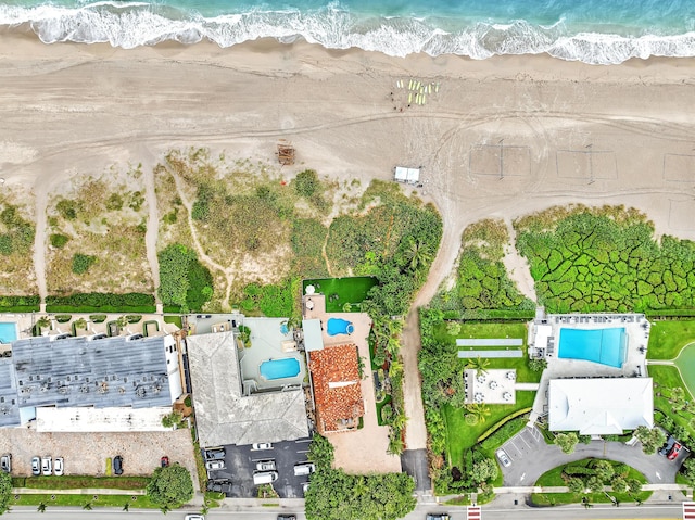 drone / aerial view featuring a beach view and a water view