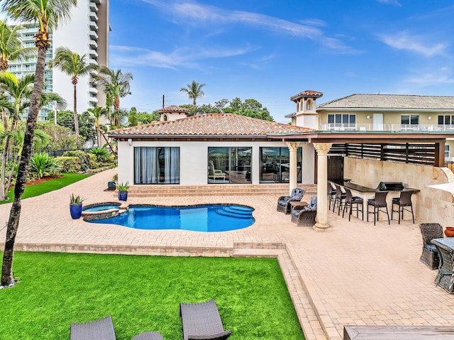 back of house featuring exterior bar, a lawn, and a patio area