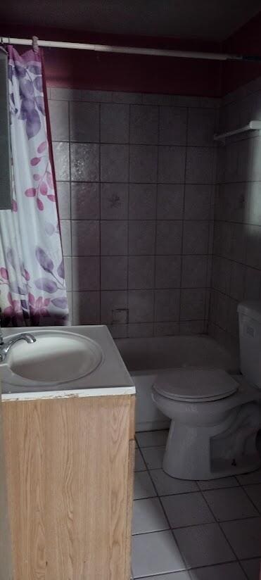 bathroom featuring tile patterned flooring, vanity, toilet, and a shower with shower curtain