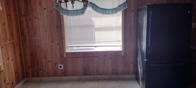 unfurnished dining area with wooden walls and light tile patterned floors