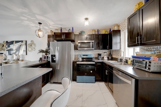 kitchen featuring dark brown cabinetry, sink, stainless steel appliances, and decorative light fixtures