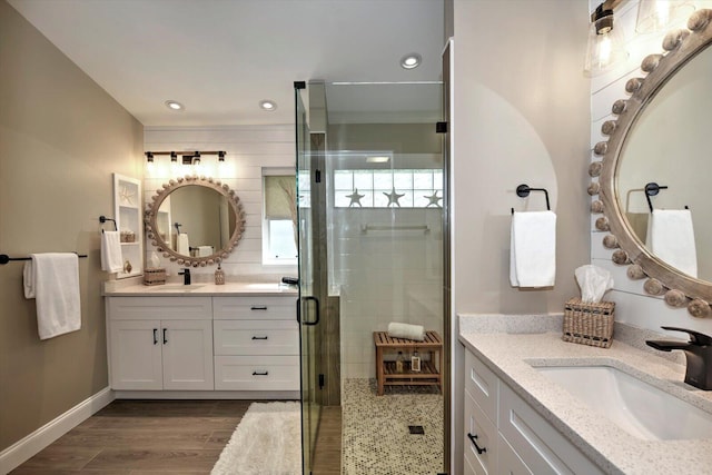 bathroom featuring hardwood / wood-style floors, a shower with door, and vanity