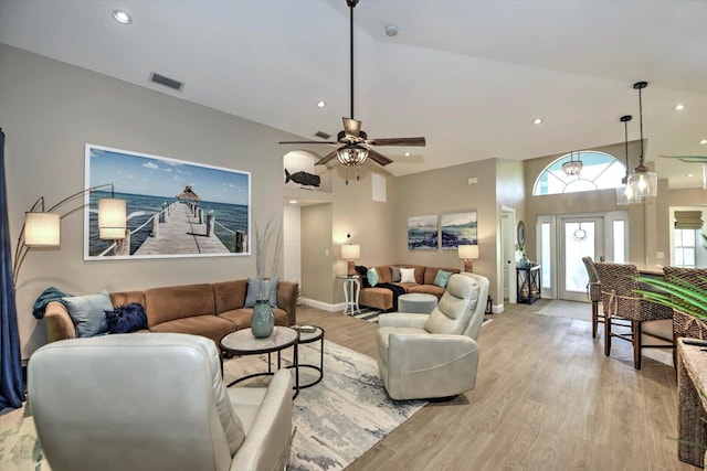 living room with light hardwood / wood-style floors, vaulted ceiling, and ceiling fan