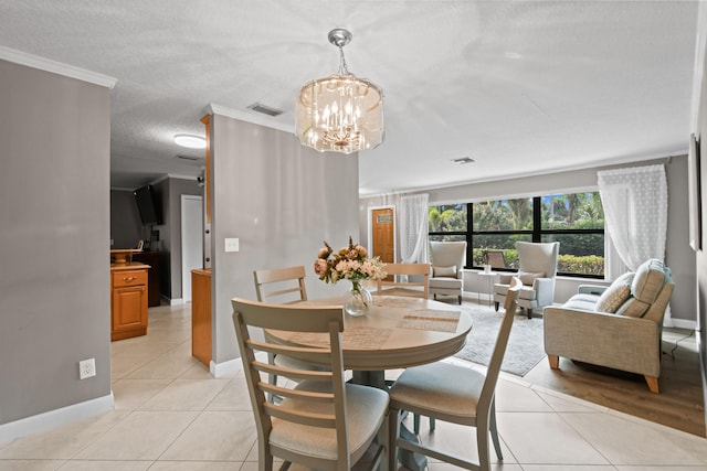 tiled dining area featuring a notable chandelier and crown molding