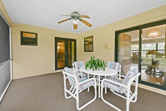 sunroom / solarium with french doors and ceiling fan with notable chandelier