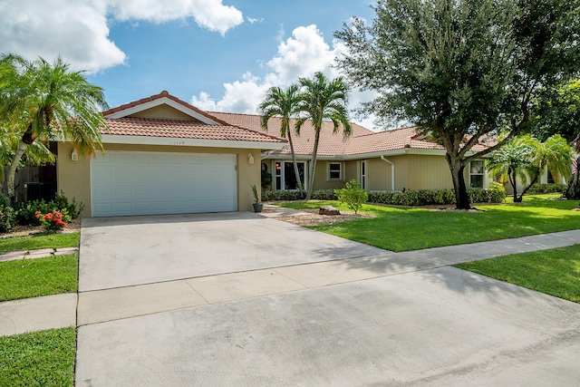 single story home featuring a garage and a front lawn