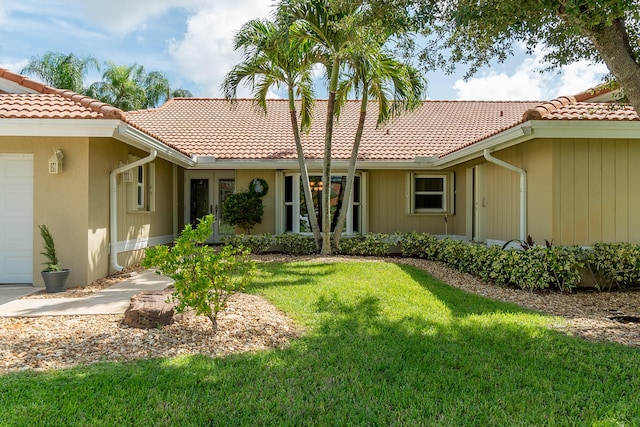 rear view of house with a garage and a lawn